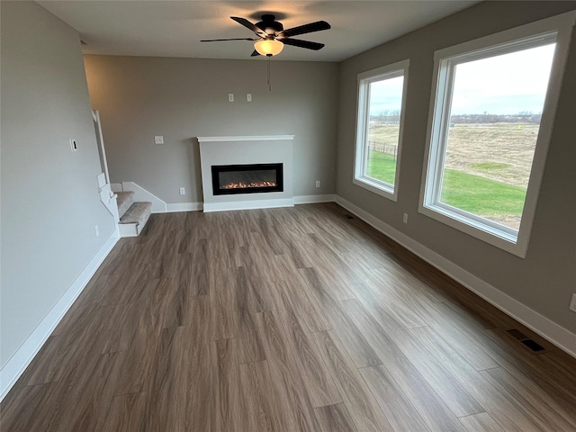 unfurnished living room featuring hardwood / wood-style flooring and ceiling fan