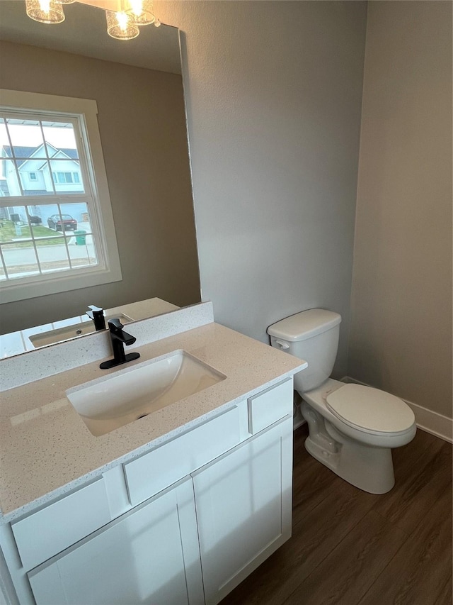 bathroom featuring vanity, hardwood / wood-style flooring, and toilet