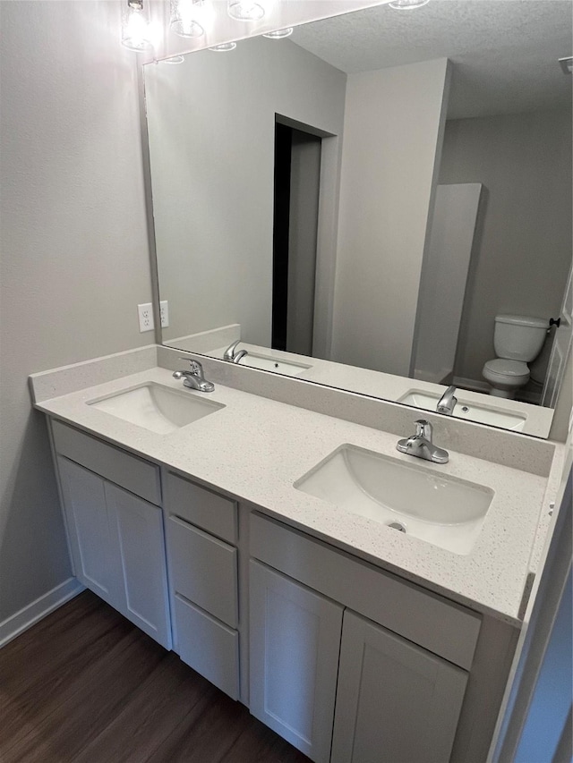 bathroom with hardwood / wood-style floors, vanity, and toilet