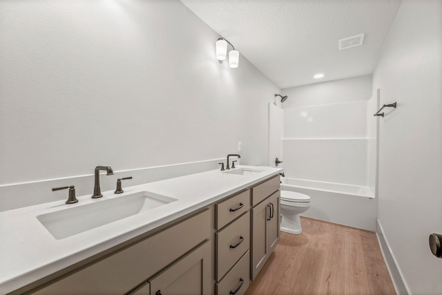 full bathroom featuring vanity, wood-type flooring, shower / bathtub combination, and toilet