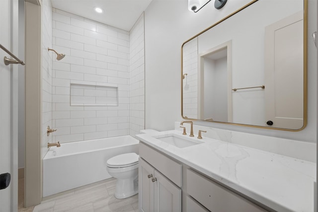 full bathroom featuring vanity, tiled shower / bath, and toilet