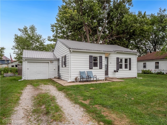 view of front of house featuring metal roof, driveway, and a front lawn