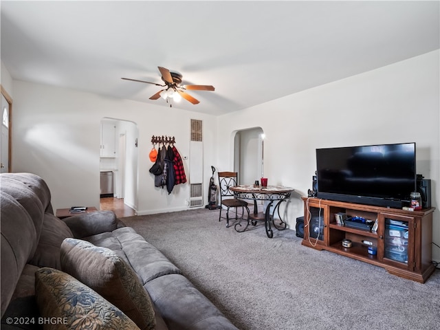 living room with arched walkways, carpet, and a ceiling fan