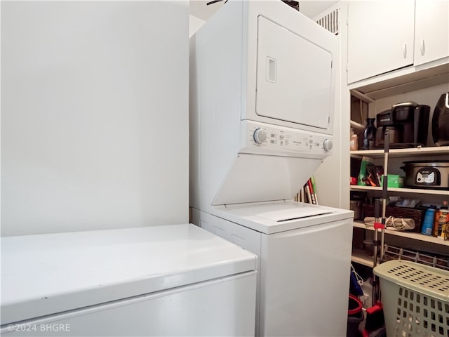 washroom with stacked washing maching and dryer