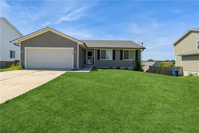 ranch-style house featuring a front yard and a garage