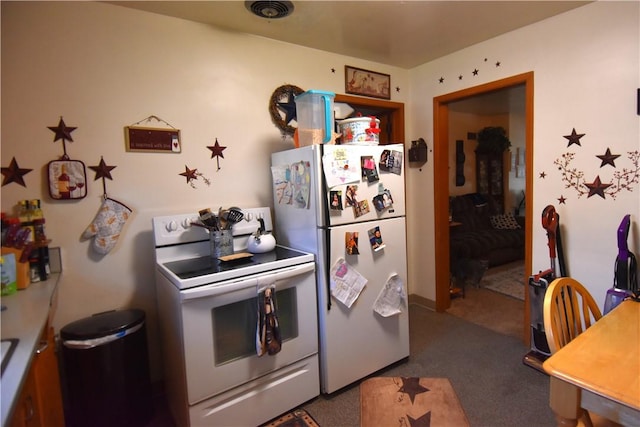 kitchen with fridge, electric range, and dark carpet