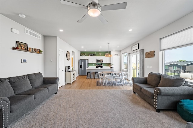 living room with ceiling fan and light wood-type flooring