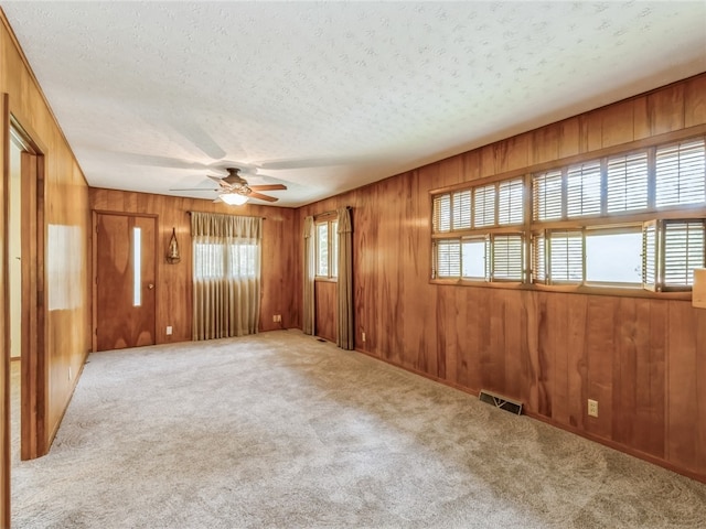 spare room with a textured ceiling and light colored carpet