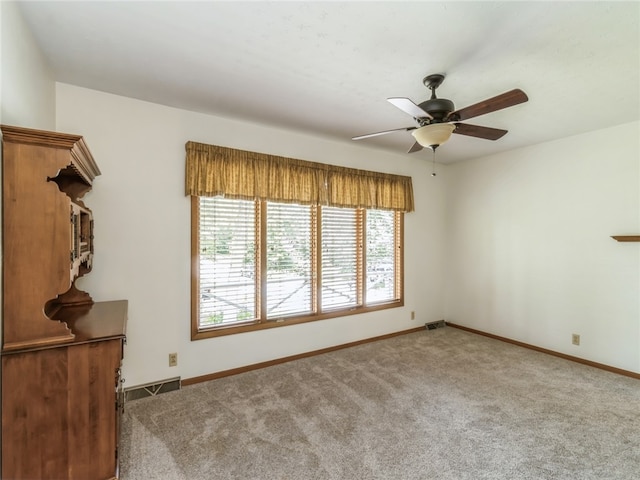 carpeted empty room featuring ceiling fan