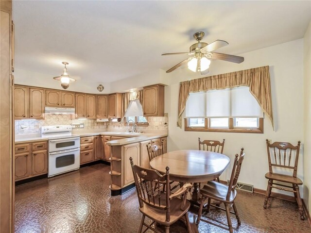 dining area featuring ceiling fan and sink