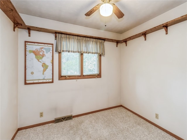 carpeted spare room with ceiling fan