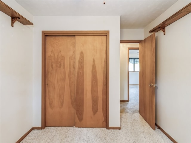 unfurnished bedroom featuring a closet and light colored carpet