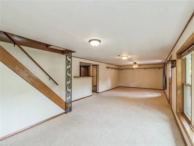 basement with ceiling fan and light carpet