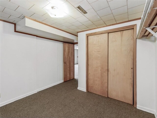 unfurnished bedroom with dark carpet and a closet