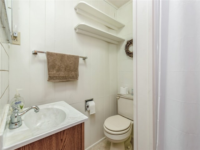 bathroom featuring tile walls, vanity, and toilet