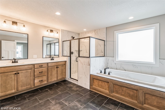 bathroom with vanity, a textured ceiling, and shower with separate bathtub