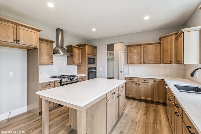 kitchen featuring wall chimney exhaust hood, stainless steel appliances, light hardwood / wood-style floors, sink, and decorative backsplash