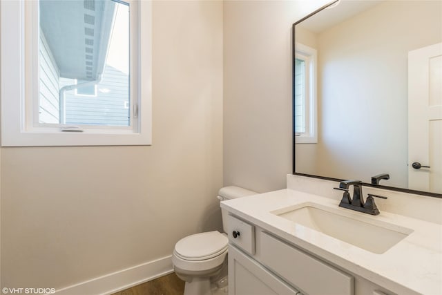 bathroom featuring toilet, hardwood / wood-style flooring, and vanity