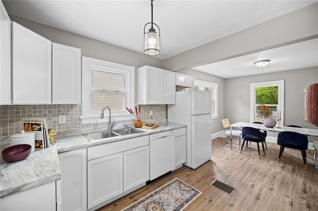 kitchen with white appliances, sink, white cabinets, and backsplash