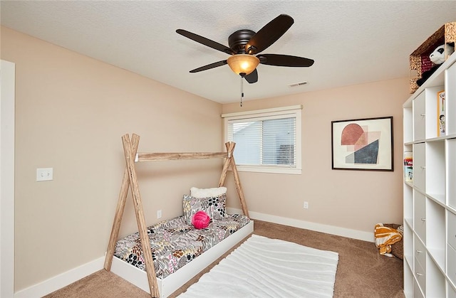 bedroom with ceiling fan, a textured ceiling, and carpet