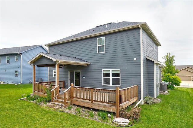 rear view of property featuring central AC, a yard, and a wooden deck