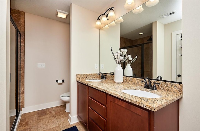 bathroom with vanity, toilet, and a shower with shower door