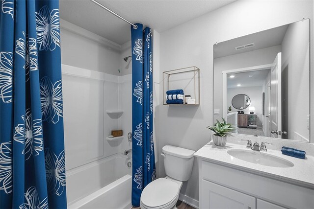 full bathroom featuring vanity, shower / tub combo with curtain, and toilet