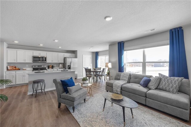 living room with a textured ceiling and dark wood-type flooring