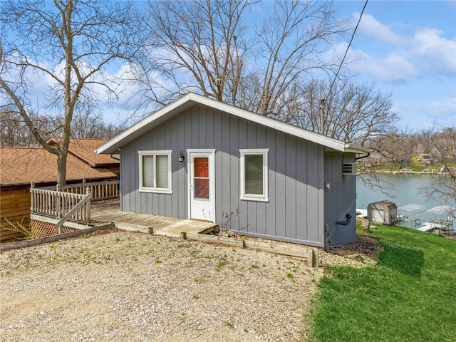 view of front of house featuring a front lawn and a deck with water view