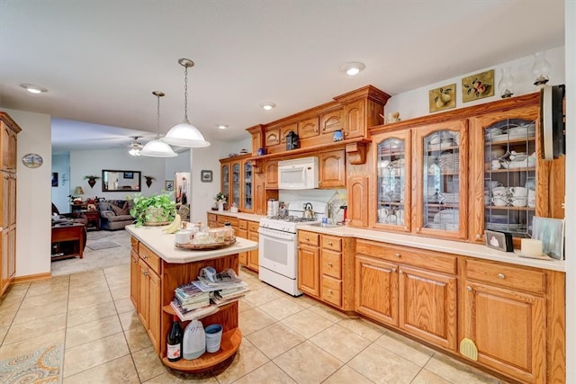 kitchen featuring pendant lighting, white appliances, a center island, and light tile patterned floors