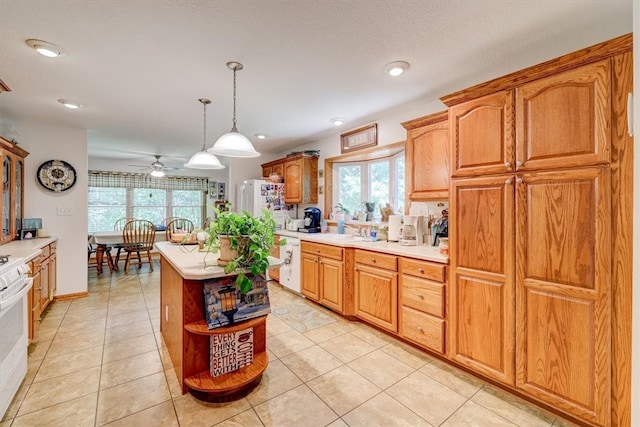 kitchen featuring ceiling fan, light tile patterned flooring, dishwashing machine, and a center island