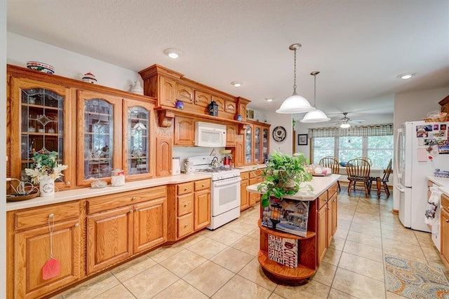 kitchen featuring white appliances, light tile patterned floors, ceiling fan, a kitchen island, and decorative light fixtures