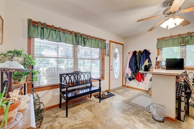 interior space featuring light tile patterned flooring, a textured ceiling, ceiling fan, and a wealth of natural light