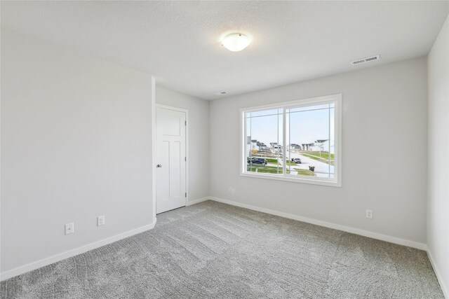 unfurnished room featuring a textured ceiling and carpet floors