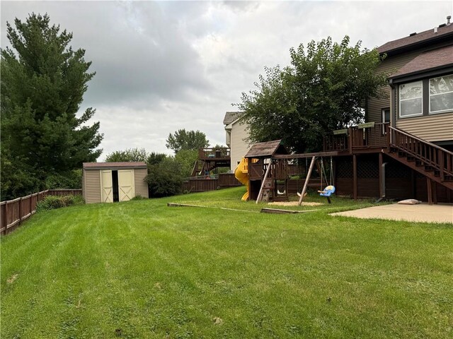 view of yard with a deck, a playground, a patio, and a storage unit