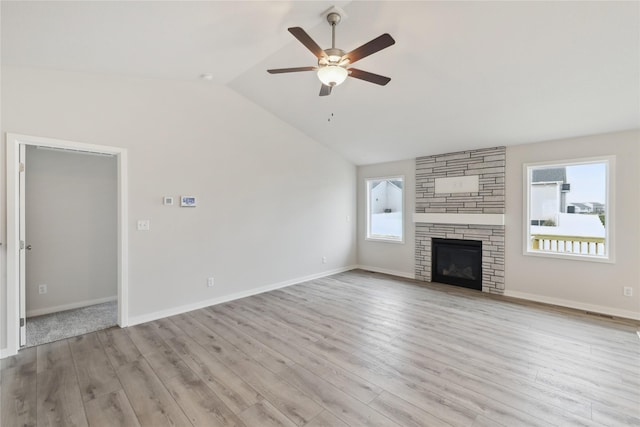 unfurnished living room with ceiling fan, lofted ceiling, a fireplace, and light hardwood / wood-style flooring