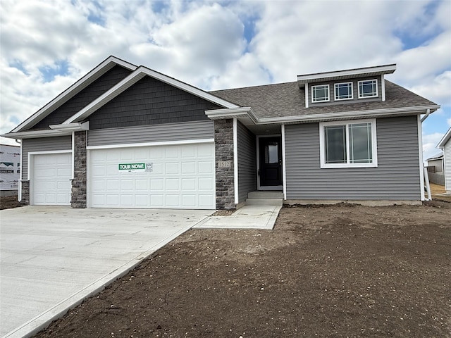 view of front of house with stone siding, roof with shingles, driveway, and an attached garage