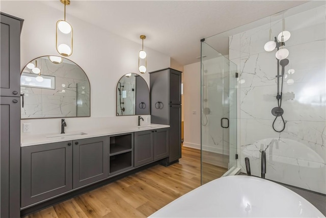 bathroom featuring hardwood / wood-style flooring, plus walk in shower, and vanity