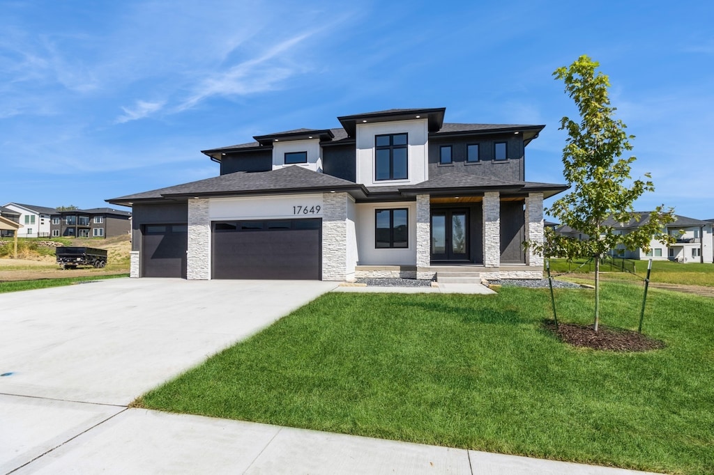 prairie-style home featuring a front lawn and a garage