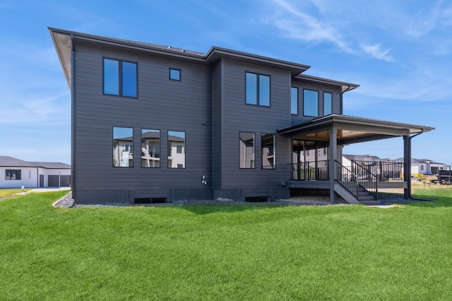 rear view of property featuring a lawn