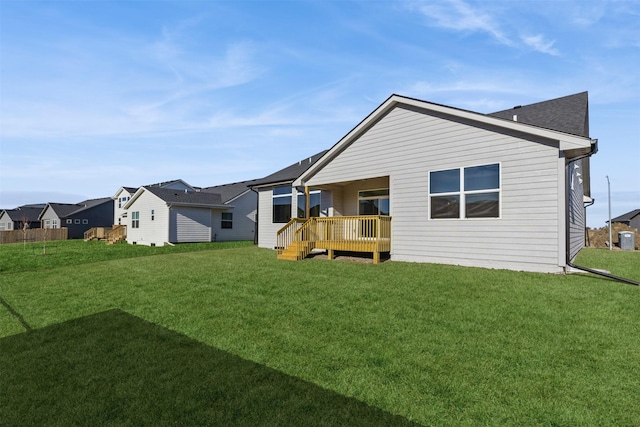 rear view of house featuring a lawn and a wooden deck