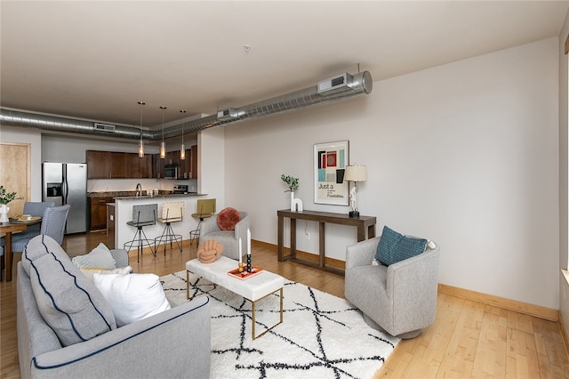 living room with sink and light hardwood / wood-style floors