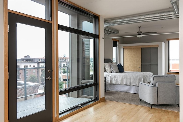 interior space featuring access to exterior, a wall of windows, a closet, and light wood-type flooring