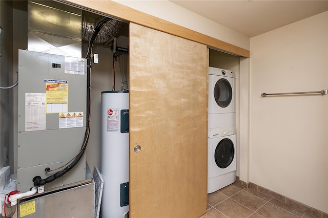 laundry area featuring water heater, tile patterned floors, and stacked washer / drying machine