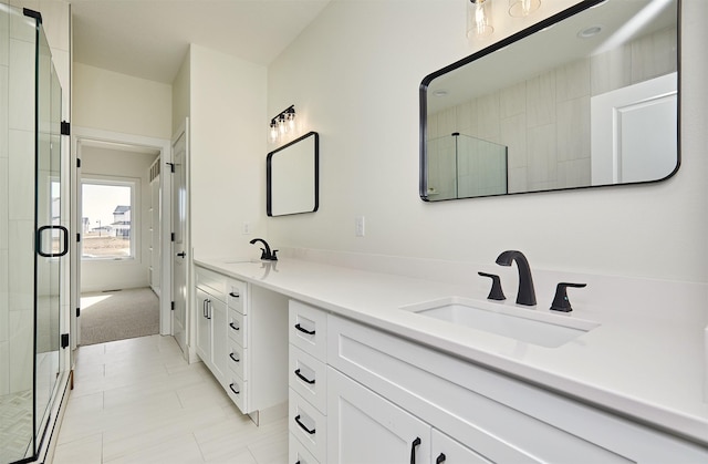 bathroom featuring a stall shower, a sink, and double vanity