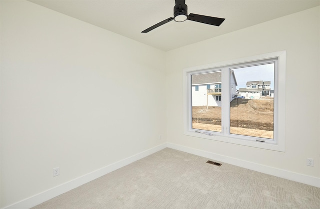 unfurnished room with visible vents, ceiling fan, light carpet, and baseboards