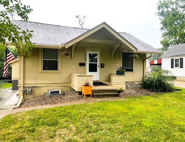 back of property featuring central AC unit and a yard