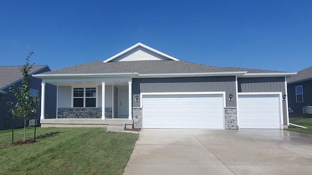 view of front of property with a garage, a front lawn, and a porch