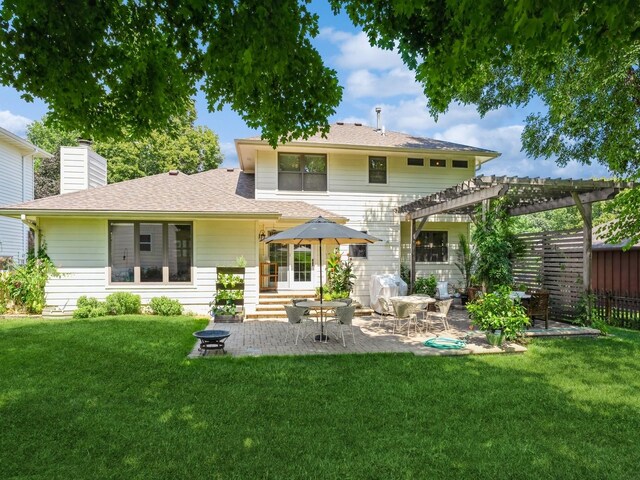 rear view of property with a yard, a patio area, and a pergola