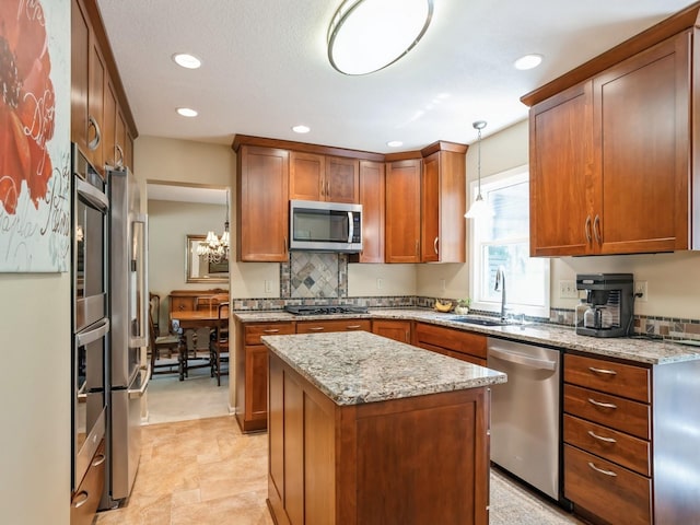 kitchen with backsplash, pendant lighting, brown cabinets, appliances with stainless steel finishes, and a sink